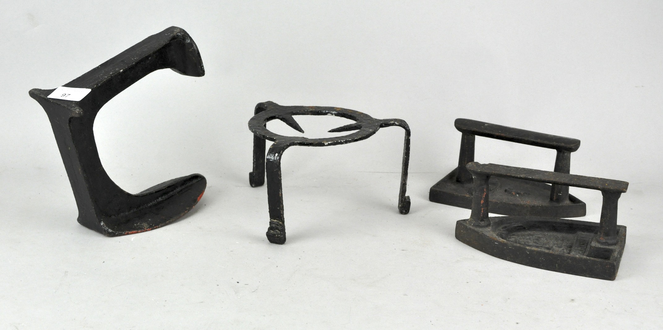 A collection of cast iron items to include; two flat irons, a shoe last and trivet.