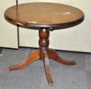 A dark stained pine round pedestal table; 73cm x 90cm dimeter.