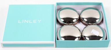 A boxed set of four steel and wood bun shaped 'David Linley' paperweights