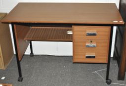 An office desk with one bank of three drawers, on casters,