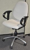 A cream coloured computer chair with rubber arms,