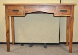 A hardwood dressing table desk with three drawer fronts raised on square legs,