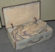 A vintage canvas suitcase containing Hessian sacks