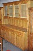 A large good quality modern oak dresser with four glazed and four solid doors and four drawers,