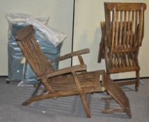 A pair of teak steamer deck chairs with cushions,