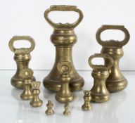 A set of nine vintage graduating brass bell weights ranging from 7lbs to 1/4oz, largest marked EIIR.