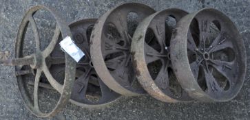 Four cast iron truck wheels and another,