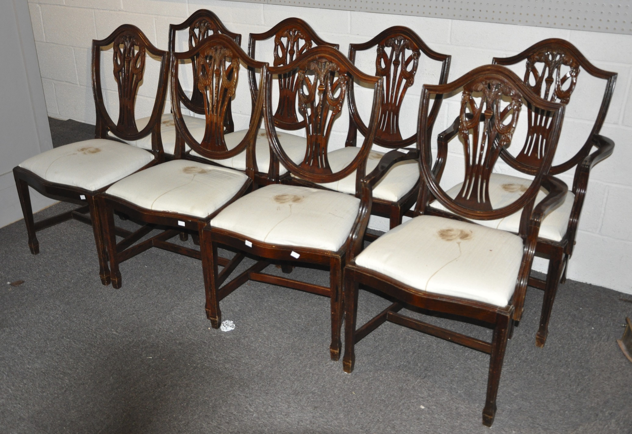 A group of eight stained oak shield back style dining chairs with pierced vase splats on