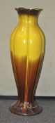 A large pottery floor vase, glazed in graduated yellow and brown, 82 cm high, nb foot damaged.