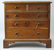 A Miniature yew wood two over three chest of drawers raised on bracket legs.