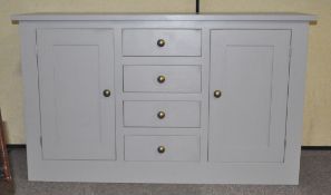 A grey painted oak sideboard unit with two panel doors and three central drawers by Jumb's