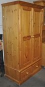 A contemporary pine two door wardrobe with two drawer base and plinth top (when constructed