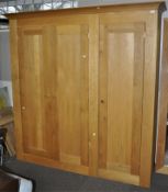 An oak double wardrobe by Jumbos of Henlow, with shaped cornice and plain panel doors,