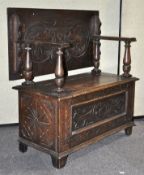 An early 20th century oak monk's bench with foliate and scroll chip carved decoration,