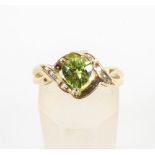 A yellow metal ring set with a heart cut peridot
