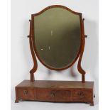 A Regency style mahogany toilet mirror, with shield shaped plate and serpentine three drawer base,