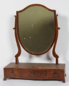 A Regency style mahogany toilet mirror, with shield shaped plate and serpentine three drawer base,