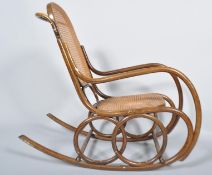 An early 20th Century Thonet style Czech bentwood rocker armchair having canework backrest and seat