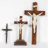 Two Crucifixes, the plaster figures of Christ on oak crosses, 42cm and 28cm high respectively,