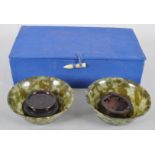 A pair of spinach jade bowls, each of flared form in mottled green hues,