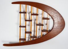 A 1960's retro vintage teak wood bespoke made wall shelving display, having a boomerang shape,