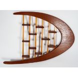 A 1960's retro vintage teak wood bespoke made wall shelving display, having a boomerang shape,