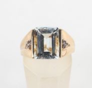 A yellow metal ring principally set with a rectangular cut colourless beryl (goshenite)