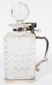 An Edwardian single bottle tantalus, the square section cut glass decanter with silver plated mount,