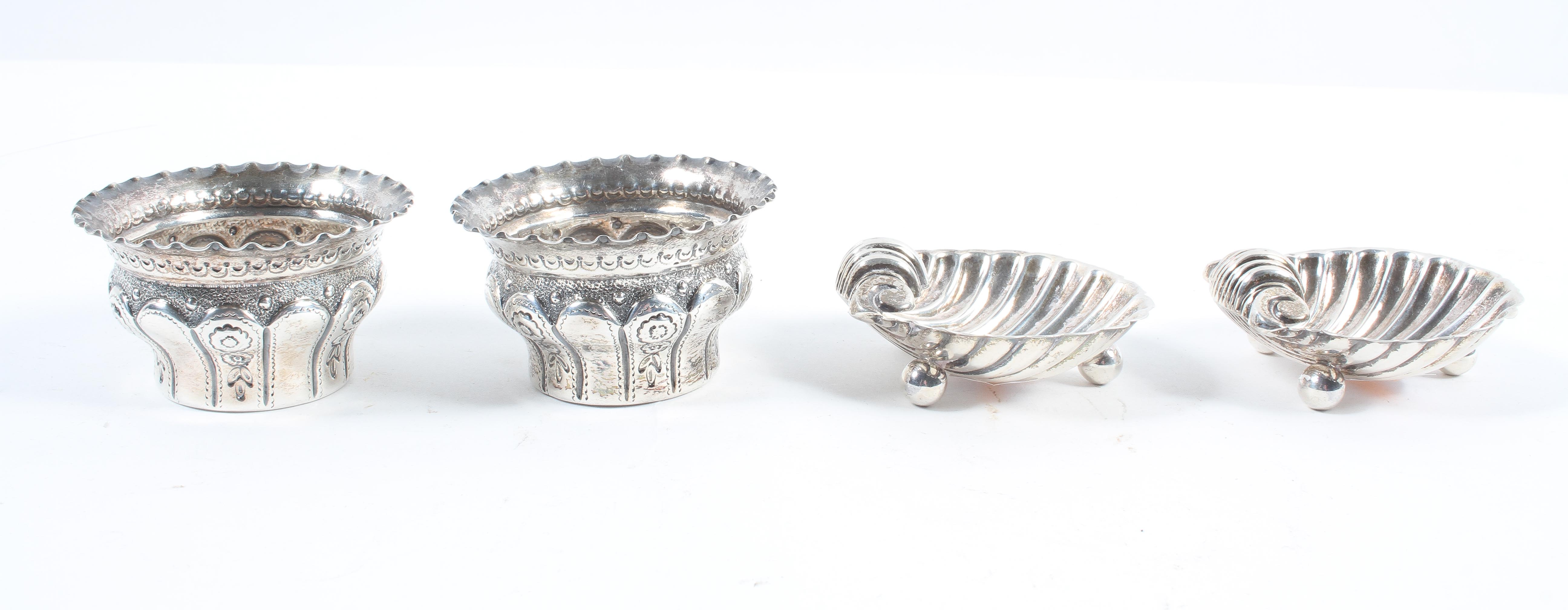 A pair of silver shell form salts, raised on ball feet,