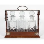 A silver plated three decanter mahogany tantalus, mid 20th century, with lockable handle,