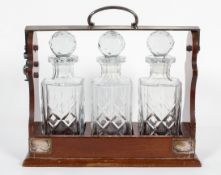 A silver plated three decanter mahogany tantalus, mid 20th century, with lockable handle,