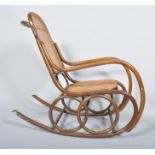 An early 20th Century Thonet style Czech bentwood rocker armchair having canework backrest and seat