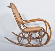 An early 20th Century Thonet style Czech bentwood rocker armchair having canework backrest and seat