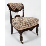 An Victorian carved walnut nursing chair, upholstered in floral fabric with stuff over seat,