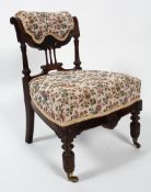 An Victorian carved walnut nursing chair, upholstered in floral fabric with stuff over seat,