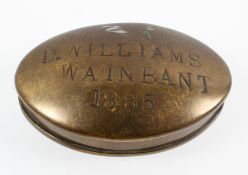 A Victorian brass snuff box and cover, of oval form, stamped D Williams/ Wainbant/1885,