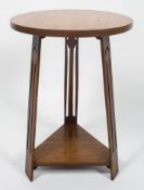 A Liberty style oak Arts and Crafts occasional table, the circular top above three tapering legs,