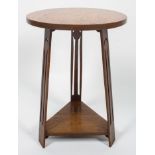 A Liberty style oak Arts and Crafts occasional table, the circular top above three tapering legs,