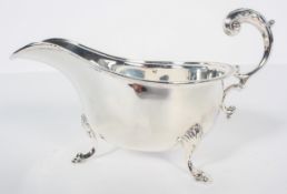 A silver sauce boat, with acanthus open scroll handle over a bead edge, raised on cabriole pad feet,