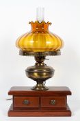 A wooden mounted electrified oil lamp with amber shade and chimney