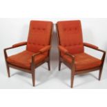 A pair of mid 20th century teak framed armchairs, with button backs,