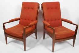 A pair of mid 20th century teak framed armchairs, with button backs,