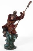 A cold painted bronze of a monkey warrior, 20th century, cast astride a high wave, holding an axe,