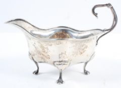 A silver sauce boat, of rounded quatrefoil form, with flying scroll handle, raised on four pad feet,
