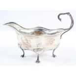 A silver sauce boat, of rounded quatrefoil form, with flying scroll handle, raised on four pad feet,