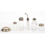 A panel cut glass dressing table jar with a stamped silver lid, decorated with cabochons and leaves,