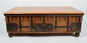 An Indian hardwood iron bound coffee table with plain bevelled edge top over a panelled body with