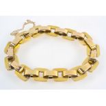A yellow metal hollow linked bracelet with push in clasp and fitted safety chain.