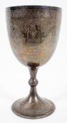 A large silver Chalice style trophy, engraved with panels of foliate strapwork to the bowl,