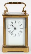 A brass carriage time piece, the white enamelled dial with black Roman numerals,